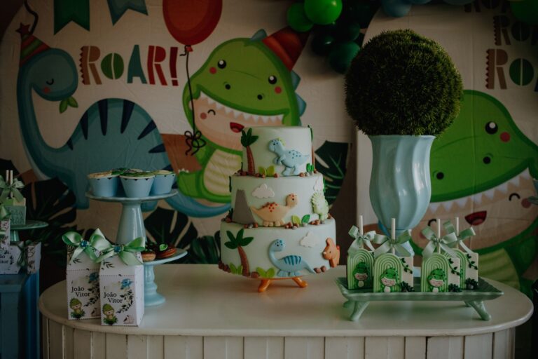 Mesa de doces tema dinossauro com bolo decorado, docinhos e lembrancinhas verdes