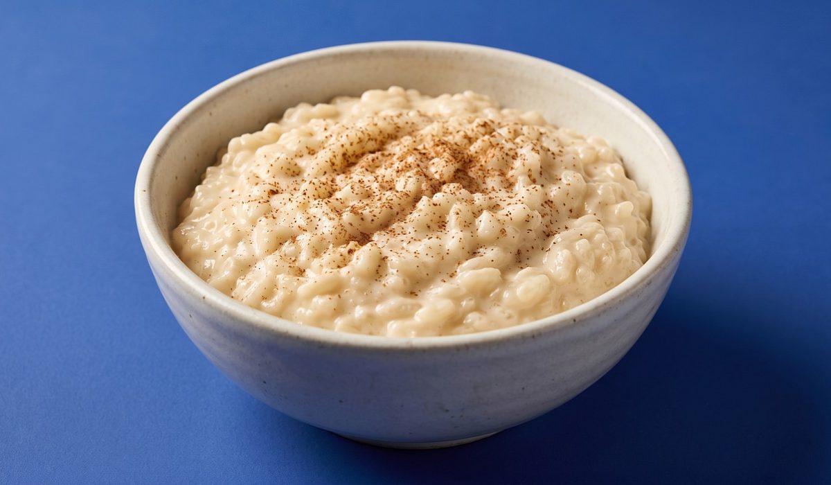 Arroz doce cremoso servido em tigela branca com canela em pó por cima