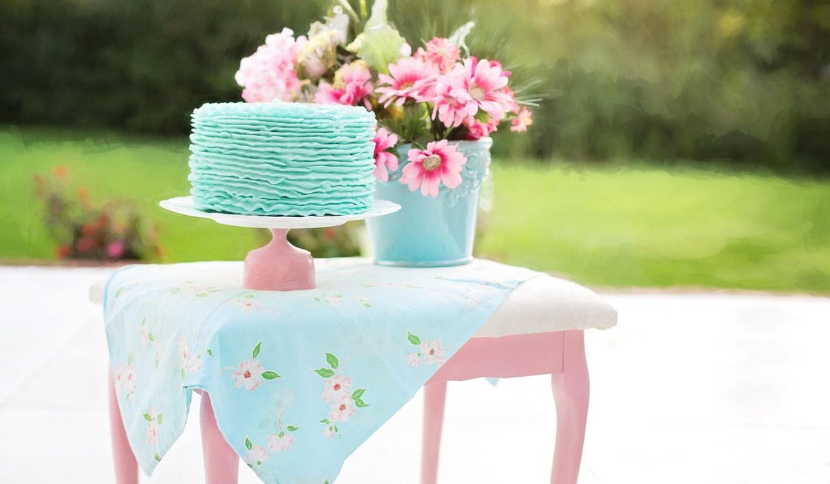 Mesa de doces de festa jardim encantado decorada com flores e bolo