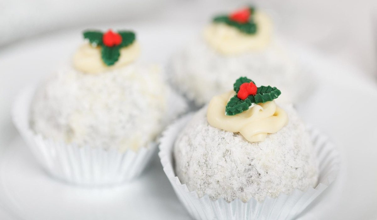 Manjar de coco cremoso desenformado e servido com calda de ameixa