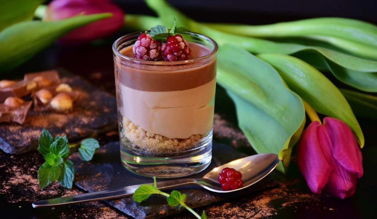 Taça de mousse de maracujá cremosa com calda e sementes por cima